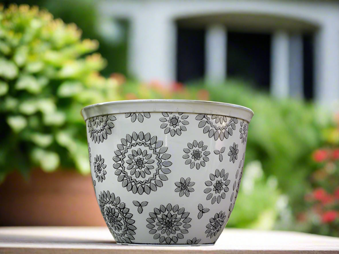 Decorative flowerpot with floral patterns against a brick wall background