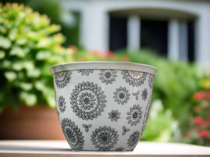 Decorative flowerpot with floral patterns against a brick wall background